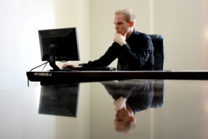 stock photo: man at desk staring intensely at computer monitor
