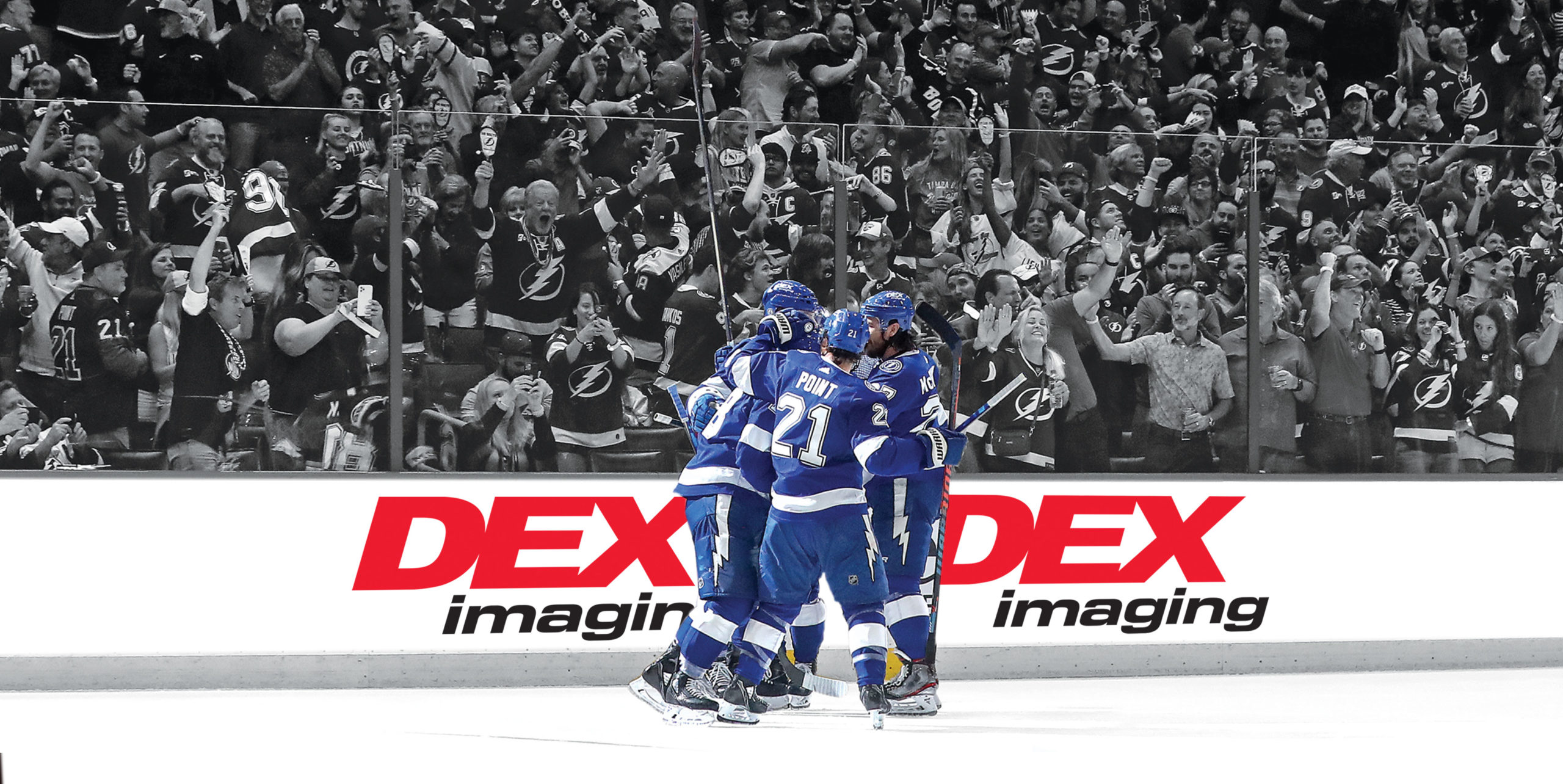 Celebration of Tampa Bay Lightning players in front of a DEX Imaging banner after winning the Stanley Cup