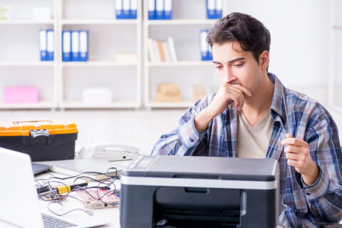 Hardware repairman repairing broken MFP printer