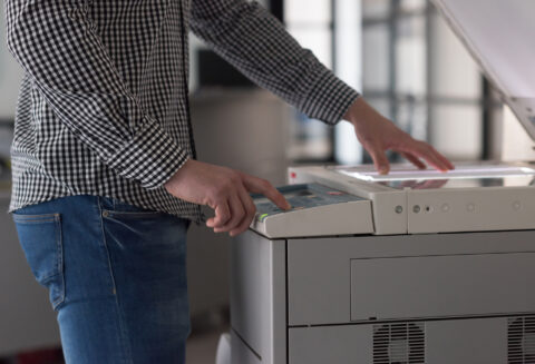 young business man copy documents on copy machine at modern startup office interior, casual clothes