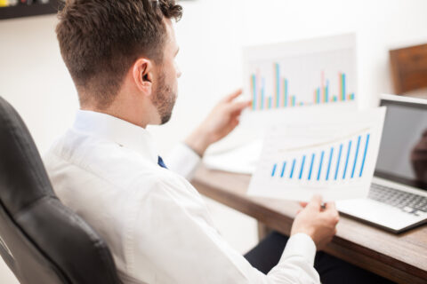 Point of view of a young businessman reviewing some performance charts in his office