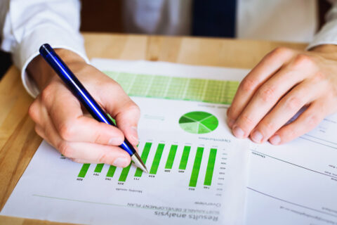 closeup of hands of an office worker evaluating sustainability reports