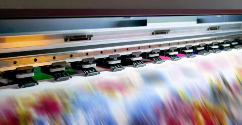 Large inkjet printing machine during production on vinyl banner.