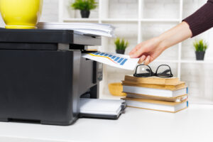 Hand removing page from a printer in office