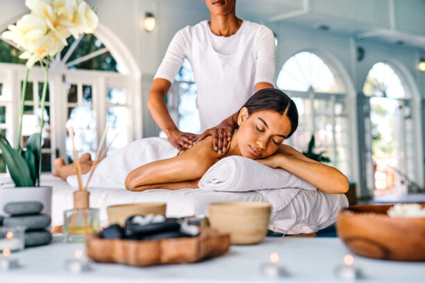 Shot of an attractive young woman lying on a bed and enjoying a massage at the spa She knows exactly where all my tension lives