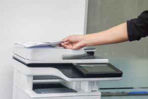 close up man put paper on printer for scanning and copying in office