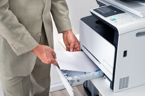 Closeup of businessman using printer in office