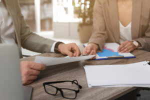 Two office workers collaborating and looking at a piece of paper together