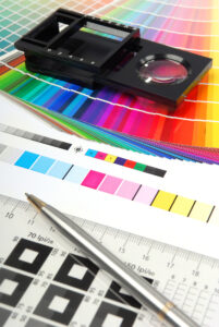 Closeup of pen and magnifier on top of color standard pages