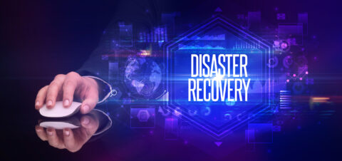 hand holding wireless peripheral with DISASTER RECOVERY inscription, cyber security concept