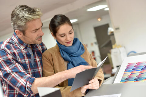 Man and woman inspecting a printed brochure