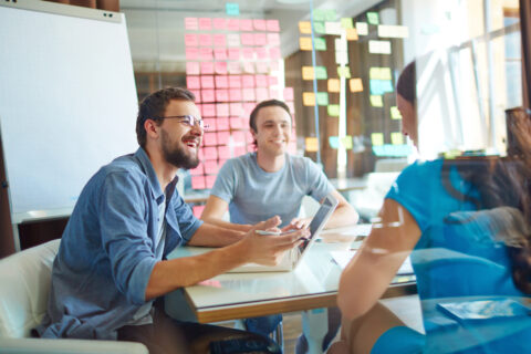 Happy workers at conference table receiving training