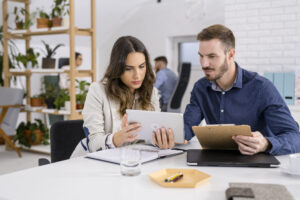 Two coworkers looking at a laptop together