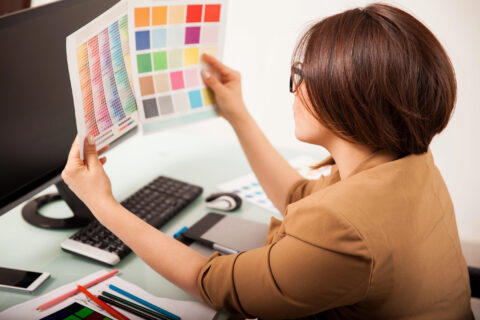 Graphic designer comparing two color samples at their computer workstation
