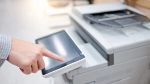 Closeup of hand using touchscreen on a business copier