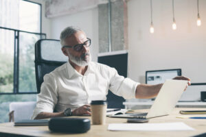 Male office worker at desk with laptop