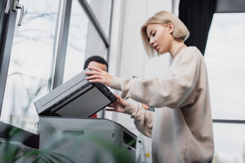 Workers using a copier in a large office
