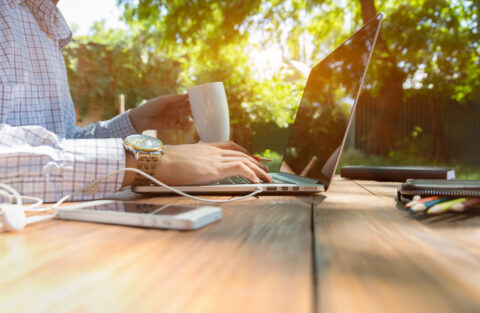 Closeup of man working on laptop at picnic table