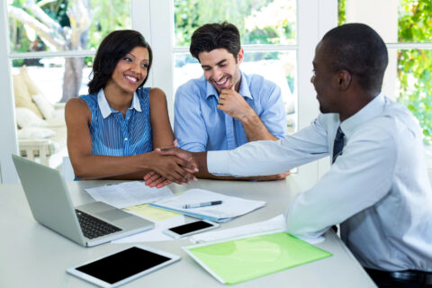 Couple shaking hands with real estate agent