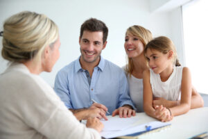 Family signing documents with real estate agent