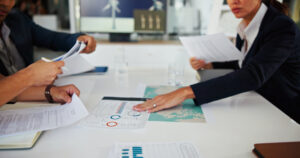 Financial representative pushing a document across a conference table