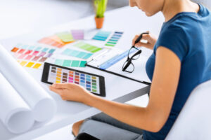 Woman looking through various color samples on her desk and on an iPad