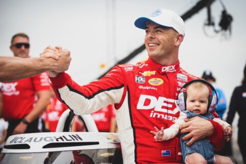 Scott McLaughlin, 2025 DEX Racing IndyCar driver, accepts a trackside handshake while holding his baby daughter