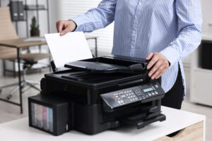 Office worker feeding paper into an office scanner