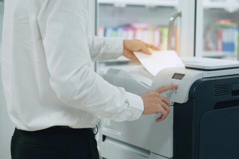Businessman scanning documents into an office copier in office