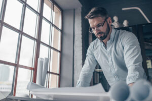 Designer reviews large printed page in design studio