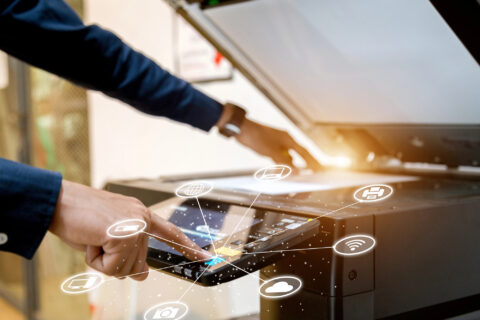 Closeup of man scanning document on a copier flatbed.