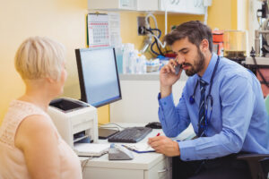 Doctor conferring with patient at desk