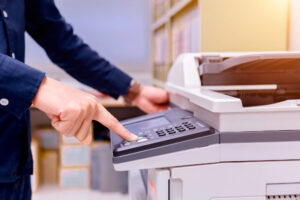 Closeup of person’s hands using copier in a library