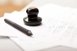 Closeup of signed contract with pen and notary stamp