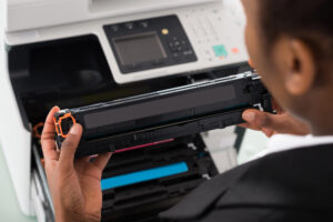 Closeup of office worker replacing toner cartridge