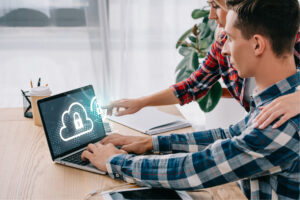 Two coworkers reviewing office security together on a laptop