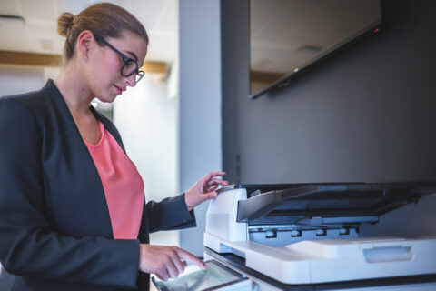 Businesswoman operating copier in office