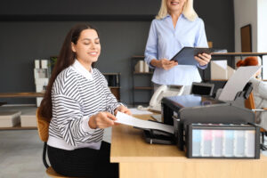 Team of coworkers using an office printer