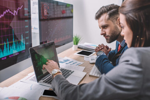 Coworkers evaluating network security on a laptop in office